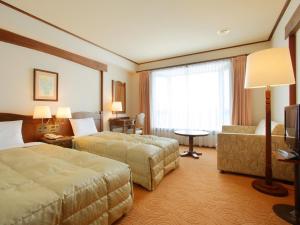大崎市Hotel Onikoube的酒店客房,设有两张床和一张沙发