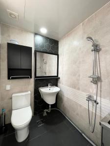 仁川市Koin Guesthouse Incheon airport的浴室配有卫生间、盥洗盆和淋浴。
