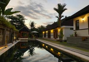 海神庙Agung Village的别墅前方设有游泳池