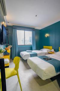 吉隆坡Hotel 28 Chow Kit Kuala Lumpur的酒店客房设有四张床和窗户。