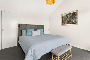 圣雷莫Cape View San Remo的一间卧室配有一张大床和一把椅子