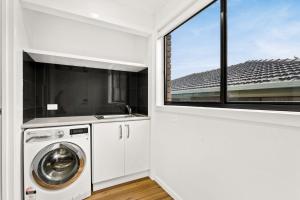 圣雷莫Cape View San Remo的洗衣房配有洗衣机和窗户