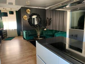 门登Lans Apartments SPA Menden Sauerland的厨房以及带绿色沙发的客厅。