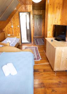 杜劳Pensiunea Novac的一间客房内配有床和电视的房间