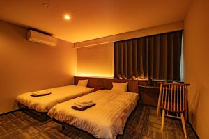 白川村CURIO Shirakawago的酒店客房设有两张床和窗户。