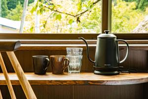 白川村CURIO Shirakawago的靠窗边桌子上的咖啡壶