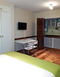 布宜诺斯艾利斯Studio Maipu的客房设有1张床、1张桌子和1台电视。