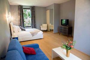圣吉尔Domaine du Prieuré d'Estagel的客厅配有床和蓝色沙发