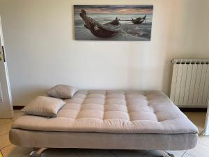 玛丽安迪安多拉Appartamento Note d’estate的墙上画的一张带软木床的房间