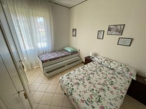 玛丽安迪安多拉Appartamento Note d’estate的一间小卧室,配有床和窗户