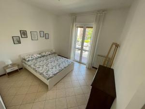 玛丽安迪安多拉Appartamento Note d’estate的一间卧室设有一张床和一个玻璃门