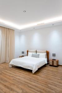 An NāmīGrande Beach的白色卧室配有一张大床和两盏灯。