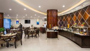 迪拜Savoy Suites Hotel Apartment - Newly Renovated的一间带桌椅的餐厅和一间酒吧