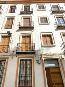 塞维利亚Hispalis Menendez Pelayo的白色的建筑,设有窗户和阳台