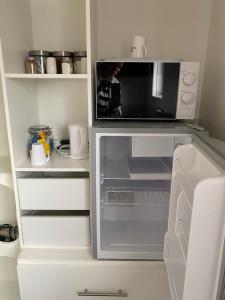彼得伯勒Quiet, spacious double bedroom!的厨房配有带微波炉的开放式冰箱