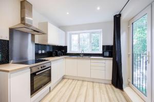 滨海绍森德Modern apartment -Perfect for Contractors & Families By Luxiety Stays Serviced Accommodation Southend on Sea的厨房配有白色橱柜和水槽