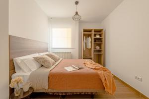 桑坦德Estilo japandi Sardinero的一间卧室配有一张带橙色毯子的床