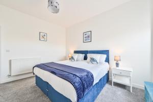 托基The Falstone Apartment的卧室配有蓝色和白色的床以及床头柜。