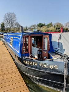 特灵Narrow Escape - 50ft Boat on the Grand Union Canal, near Tring的一艘蓝色的船停靠在码头旁边