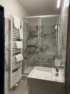 奥洛穆茨巴拉兹酒店的带淋浴和白色盥洗盆的浴室