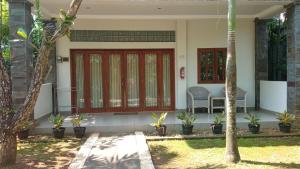 哲帕拉格科乡村旅馆的院子里有红色门和椅子的房子