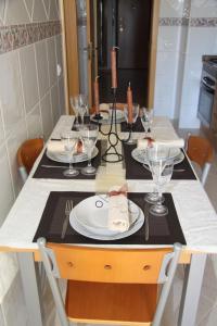波尔蒂芒Apartamento Arade Portimao的餐桌,上面有盘子和玻璃杯
