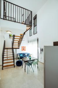 贝尔谢巴הרצל בוטיק מבית דומוס - Herzl Boutique Apartments by Domus的客厅设有楼梯和桌子