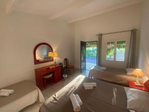 萨里索伦札拉Les Lodges de la Plage U Dragulinu的酒店客房,设有两张床和镜子