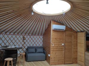 拉茨凯韦Jurtafarm Ráckeve - a nomád luxus的圆顶帐篷内的房间,配有椅子和桌子
