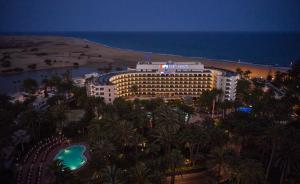 马斯帕洛马斯海滨棕榈滩酒店的棕榈树和海洋海滩上的酒店