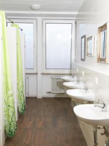 慕尼黑PM旅舍的浴室设有4个水槽和一排镜子