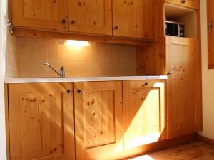 琴山朗勒堡Appartement Lanslebourg-Mont-Cenis, 2 pièces, 4 personnes - FR-1-508-149的一个带木制橱柜和水槽的厨房