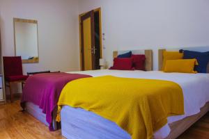 戈伊什Casa de Campo Vale do Ceira的一间卧室配有一张带色彩缤纷枕头的大床