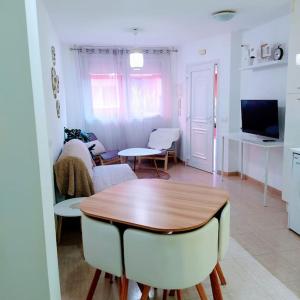 圣伊西德罗Apartamento Izaña的厨房以及带桌椅的起居室。