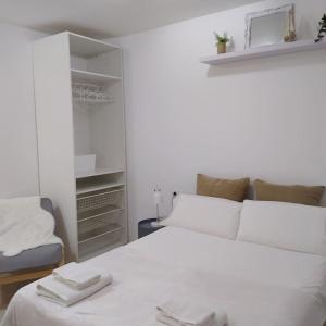 圣伊西德罗Apartamento Izaña的卧室配有白色的床和椅子