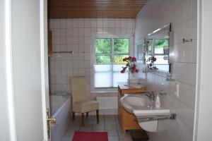 巴特贝特里希Gästehaus Beurener Mühle的浴室配有盥洗盆、卫生间和浴缸。