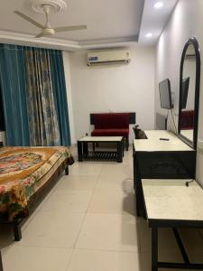 JagādhriHotel Raman's的一间卧室配有一张床、一张沙发和一面镜子