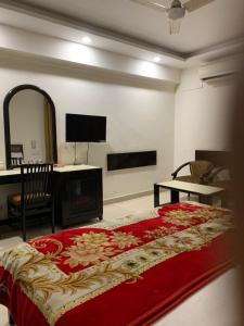 JagādhriHotel Raman's的一间卧室配有一张带红色毯子的大床