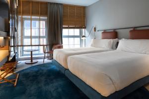 波尔图ICON Duplo Ribeira的酒店客房设有一张白色大床和一张书桌
