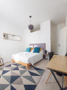 蒙吕松Artbleu -Tout Confort - Idéal Pros - Proche commerces的一间卧室配有蓝色和黄色枕头的床