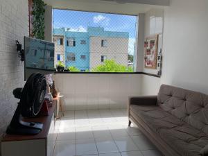 马塞约Ape em Maceió的带沙发和大窗户的客厅