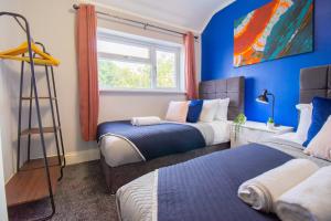 布里斯托Stunning House Free Parking Garden WiFi的配有两张床铺的蓝色墙壁和窗户