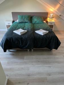 德科赫Parnassia的一间卧室配有一张床,上面有两条毛巾