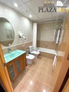 菲格拉斯广场旅馆酒店的浴室配有卫生间、浴缸和水槽。