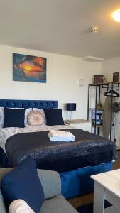 哈德斯菲尔德Bv Cosy Studio Eleven At Deighton Huddersfield的一间卧室配有一张蓝色的床和一张沙发