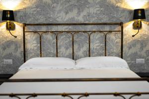 巴尼奥雷焦La Dimora del Principe的卧室配有一张带两盏灯的墙壁床。