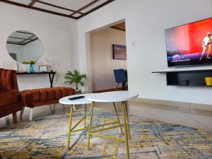 基塔莱The Nest Airbnb - Milimani, Kitale的客厅配有桌子和电视