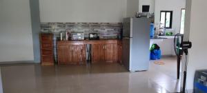 BacunganEco greene farm的厨房配有冰箱和木制橱柜。