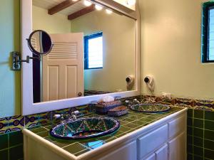 珀拉什奇亚Tranquility Beach Suites的一间带两个盥洗盆和大镜子的浴室