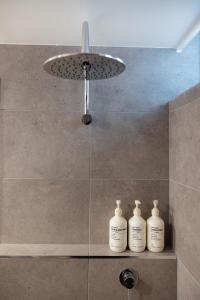 塔南达Barossa Weintal Hotel的四个白色瓶子坐在淋浴架上